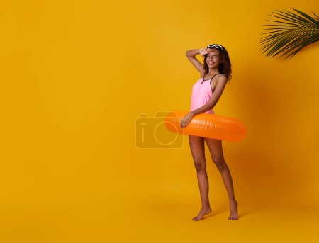 Photo for Full length happy young sexy woman slim body wear swimsuit posing with inflatable rubber ring isolated on vivid yellow color wall background studio. - Royalty Free Image