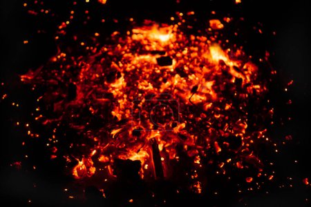 Blurred background of burning coals in a barbecue brazier, close-up