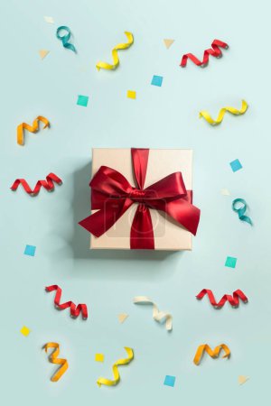 Foto de Múltiples colores confeti y una caja de regalo sobre fondo azul claro. - Imagen libre de derechos