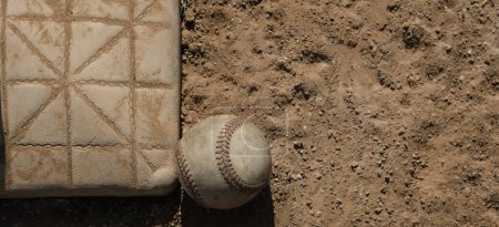 Téléchargez les photos : Baseball ball by base on dirt sports field close up, espace de copie sur fond de bannière - en image libre de droit
