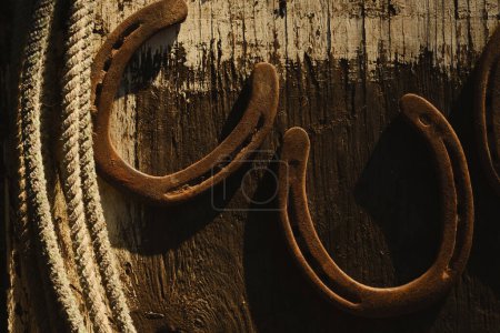 Téléchargez les photos : Vieilles fers à cheval rouillés avec corde sur la surface en bois - en image libre de droit