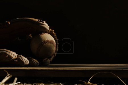 Foto de Primer plano de guante de béisbol de cuero con bola en el fondo oscuro - Imagen libre de derechos