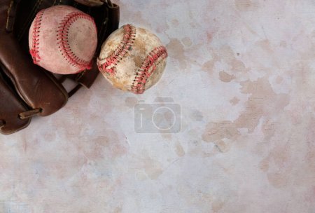 Téléchargez les photos : Équipement de baseball grunge vintage avec de vieilles boules et gants usagés posés sur un fond de texture sale. - en image libre de droit
