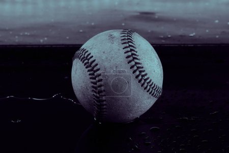 Dark moody baseball in blue color closeup, used in sports game.