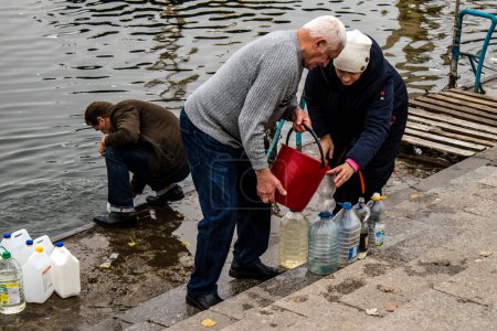 Foto de Residentes de Kherson en Ucrania, recogiendo agua en el río Dnipro. El ejército ruso ha bombardeado la infraestructura de la ciudad y el suministro de agua está completamente cortado. Tropas rusas abandonaron Kherson después de una ocupación de nueve meses y una contraofensiva - Imagen libre de derechos