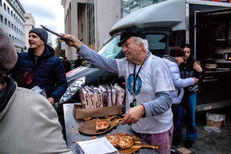 Téléchargez les photos : Une organisation internationale de bénévoles prépare et livre des pizzas aux habitants de Kherson sur la place principale du centre-ville. De nombreuses aides humanitaires apportent leur soutien en nourriture ou en vêtements à des personnes qui manquent de tout. - en image libre de droit