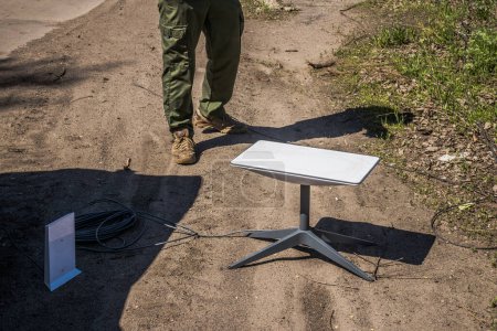 Téléchargez les photos : Soldat ukrainien utilisant Starlink, une constellation Internet par satellite exploitée par SpaceX, fournissant une couverture Internet par satellite. Depuis le début de la guerre, Starlink a considérablement aidé les soldats ukrainiens dans les zones de combat où il y a - en image libre de droit