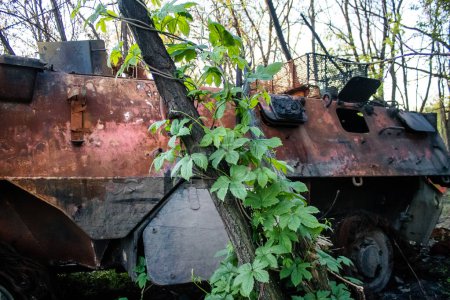 Téléchargez les photos : Un véhicule blindé BTR de l'armée ukrainienne a été détruit par des tirs d'artillerie dans la zone de combat près de Bahkmut, en bordure d'une forêt. Les armées russes et ukrainiennes se font face dans le Donbass, les combats sont intenses et les chars sont des cibles de choix. - en image libre de droit