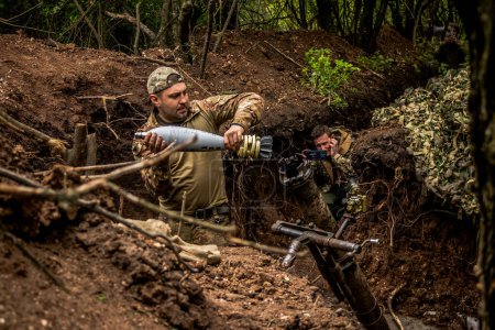 Foto de Soldado ucraniano del 28º Batallón de Artillería disparando un mortero de 120 mm contra un objetivo ruso en la línea cero en el bosque cerca de Bakhmut. Los ejércitos ruso y ucraniano chocan en el Donbass, la lucha es intensa y la batalla está furiosa. Con un - Imagen libre de derechos