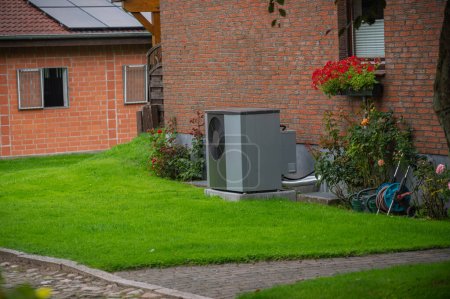 Luftwärmepumpe an der Außenfassade des alten Hauses installiert. Nachhaltige Heizlösungen für Altbauten. Luftquelle Wärmepumpe neben Wohnhaus.