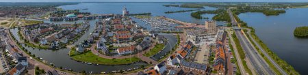Panorama-Luftaufnahme vom Hafen und der Stadt Harderwijk mit Wasserbrücke Aquaduct Veluwemeer, die es dem Fahrzeug- und Wasserverkehr ermöglicht, über- oder untereinander zu fahren, Niederlande. 