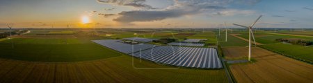 Sustainable installation of photovoltaic solar power plant and wind turbine farm on agricultural terrain for minimizing environmental impact. Solar panels bathed in the soft embrace of the sun's rays