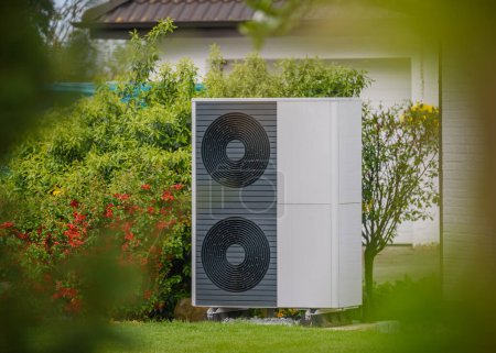 Luftwärmepumpe an der Außenfassade des Wohnhauses installiert. Nachhaltige Heizlösungen für Gebäude. Luftquelle Wärmepumpe neben Wohnhaus.