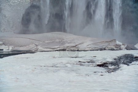 Majestätischer Wasserfall mit Nebel und turbulentem Fluss im Vordergrund, der die Kraft und Schönheit der Natur zur Schau stellt. Ort: Skogafoss Wasserfall Island.