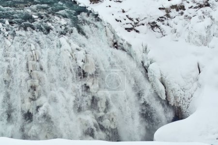 Majestic frozen waterfall with icicles and snow Location: Gullfoss Falls, Iceland.