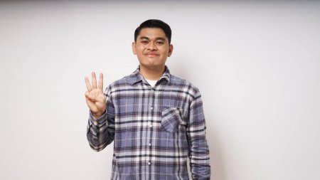 Foto de Joven asiático hombre mostrando feliz cara expresión mientras dando tres dedos signo - Imagen libre de derechos
