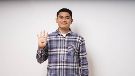 Foto de Joven asiático hombre mostrando feliz cara expresión mientras dando cuatro dedos signo - Imagen libre de derechos