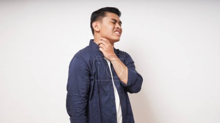 Photo for Young Asian man touching his throat showing in pain expression on white background. studio shot - Royalty Free Image