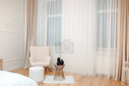 Photo for Stylish and cozy luxury apartment with lounge chair, table and wooden floors. Details of master bedroom - Royalty Free Image