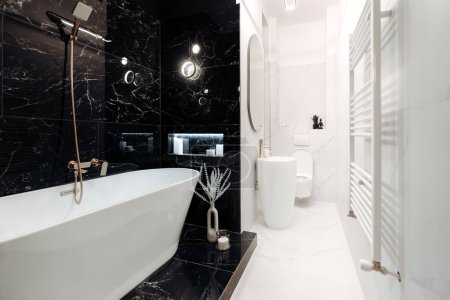 Photo for Spacious, fancy black and white marble bathroom with freestanding bathtub - Royalty Free Image