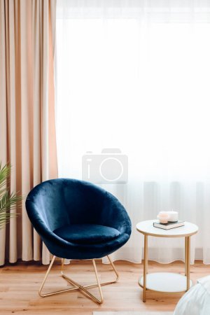 Photo for Reading area with comfortable chair and table next to window on modern apartment - Royalty Free Image