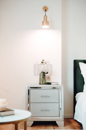 Photo for Close up of beautiful nightstand in elegant and comfortable modern bedroom. Interior design details - Royalty Free Image