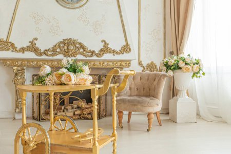 Photo for Luxurious expensive interior of a large baroque royal living room. antique furniture, gold trim, huge windows, fireplace with gold stucco on the walls. full of daylight - Royalty Free Image