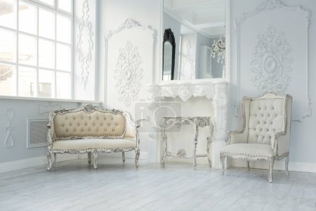 Foto de Lujo rico diseño interior de la sala de estar con elegantes muebles clásicos y decoraciones de pared. Habitación blanca grande con ventana grande - Imagen libre de derechos