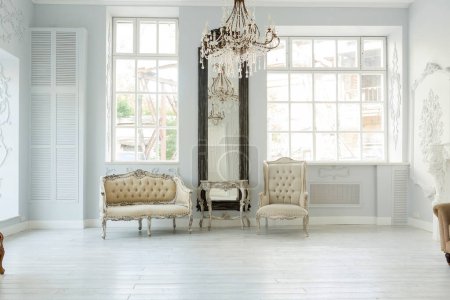 Foto de Lujo rico diseño interior de la sala de estar con elegantes muebles clásicos y decoraciones de pared. Habitación blanca grande con ventana grande - Imagen libre de derechos