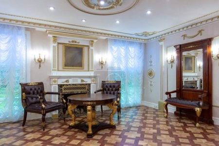luxuriöse Wohnzimmereinrichtung mit schönen alten geschnitzten Möbeln in Goldfarbe mit Dekorationen an den Wänden im Stil des königlichen Palastes