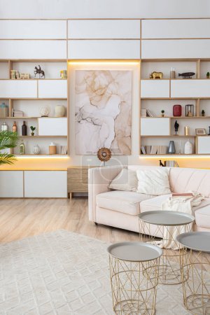 Téléchargez les photos : Design intérieur spacieux studio lumineux de style scandinave et couleurs blanc pastel et beige chaleureux. mobilier tendance dans le salon et des détails modernes dans le coin cuisine. - en image libre de droit