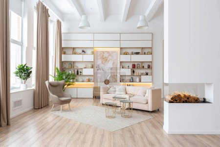 espacioso y luminoso apartamento estudio de diseño interior en estilo escandinavo y cálidos colores pastel blanco y beige. muebles de moda en la sala de estar y detalles modernos en el área de la cocina.