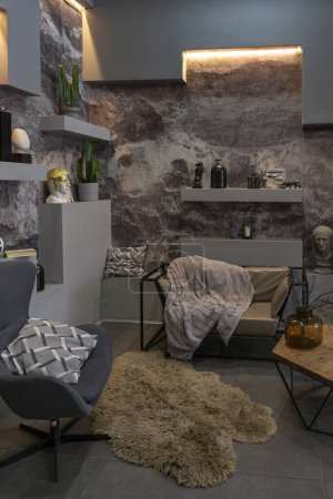 modern sitting place interior design with decorative stone walls in grey. stone wood, tiles and led lighting in the design of the room.
