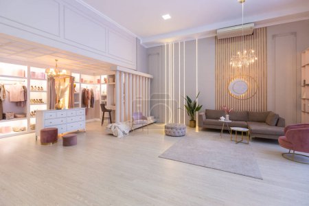 Photo for Spacious expensive luxury bright interior of open-plan apartment in pink colors with dressing room, bedroom area and cozy area for guests with soft furniture. fashionable LED lighting and huge windows - Royalty Free Image