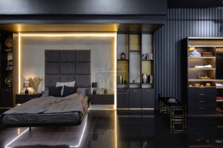 dunkel moderne stilvolle männliche Wohnungseinrichtung mit Beleuchtung, dekorativen Wänden, Kamin, Ankleidebereich und riesigem Fenster