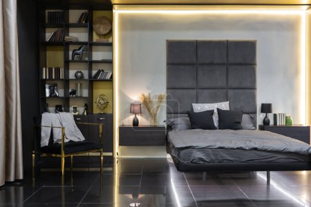 Foto de Oscuro moderno elegante apartamento masculino interior con iluminación, paredes decorativas, chimenea, vestidor y ventana enorme - Imagen libre de derechos