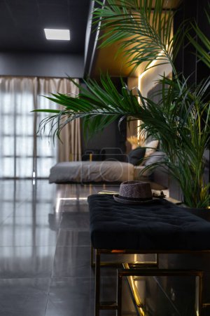 sombre moderne élégant appartement masculin intérieur avec éclairage, murs décoratifs, cheminée, dressing et grande fenêtre