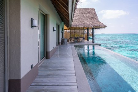 Luxuriöse Außenfassade einer sehr teuren Villa mit reichem Wasser auf den Malediven, dekoriert mit natürlichem Holz.