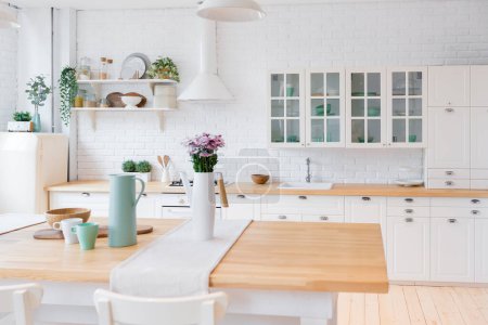 Photo for Stylish kitchen in light colors in a trendy modern duplex apartment with large high windows. - Royalty Free Image
