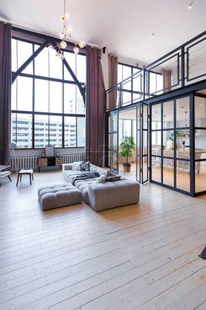 trendy modern design two-level apartment with large high windows. The stylish living room and kitchen in bright colors are undressed by a glass partition. bedroom on the second floor.