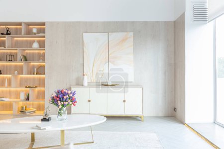 design intérieur moderne de la salle de séjour dans le studio dans des couleurs douces chaudes. éclairage intégré décoratif et mobilier beige doux