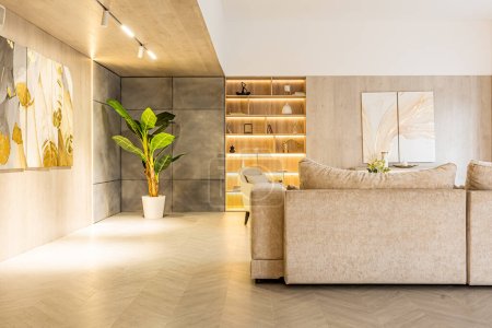 design intérieur moderne de la salle de séjour dans le studio dans des couleurs douces chaudes. éclairage intégré décoratif et mobilier beige doux