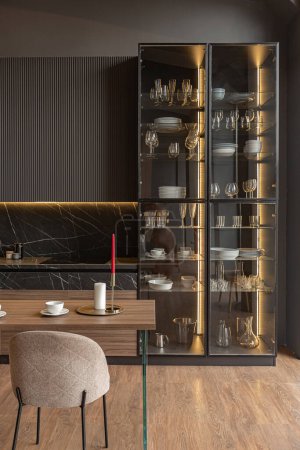 Küchenbereich in einem schicken teuren Interieur eines Luxus-Hauses mit dunkelschwarzem und braunem modernem Design mit Holzverkleidung und LED-Licht