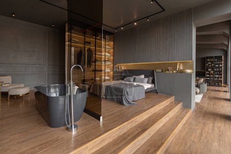 Foto de Dormitorio y baño independiente detrás de una partición de vidrio en un elegante interior caro de una casa de lujo con un diseño moderno oscuro con acabado de madera y luz led - Imagen libre de derechos