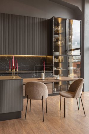Foto de Área de cocina en un elegante interior caro de una casa de lujo con un diseño moderno negro y marrón oscuro con acabado de madera y luz led - Imagen libre de derechos