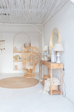 Téléchargez les photos : Intérieur confortable d'un appartement lumineux de style balinais avec murs blancs, chaise en bambou, grand canapé blanc et décorations - en image libre de droit