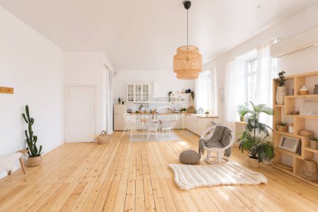 lindo acogedor diseño interior de luz del apartamento con un diseño gratuito de la cocina y las áreas del dormitorio. muchas ventanas, un suelo de madera y un columpio colgante.