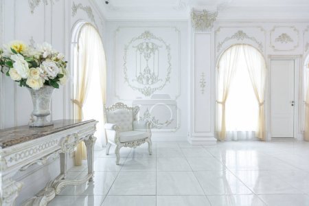 Photo for Luxury royal posh interior in baroque style. very bright, light and white hall with expensive oldstyle furniture. large windows and stucco ornament decorations on the walls - Royalty Free Image