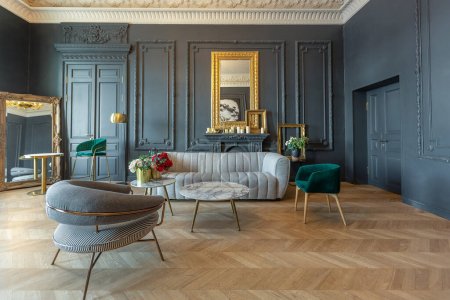 Photo for Chic interior of the room in the Renaissance style of the 19th century with modern luxury furniture. walls of noble dark color are decorated with stucco and gilded frames, wooden parquet. - Royalty Free Image