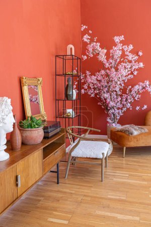 Foto de Antiguo interior vintage en el siglo 19 sala de estar de estilo con paredes de color rojo brillante, suelo de madera y luz solar directa dentro de la habitación. - Imagen libre de derechos
